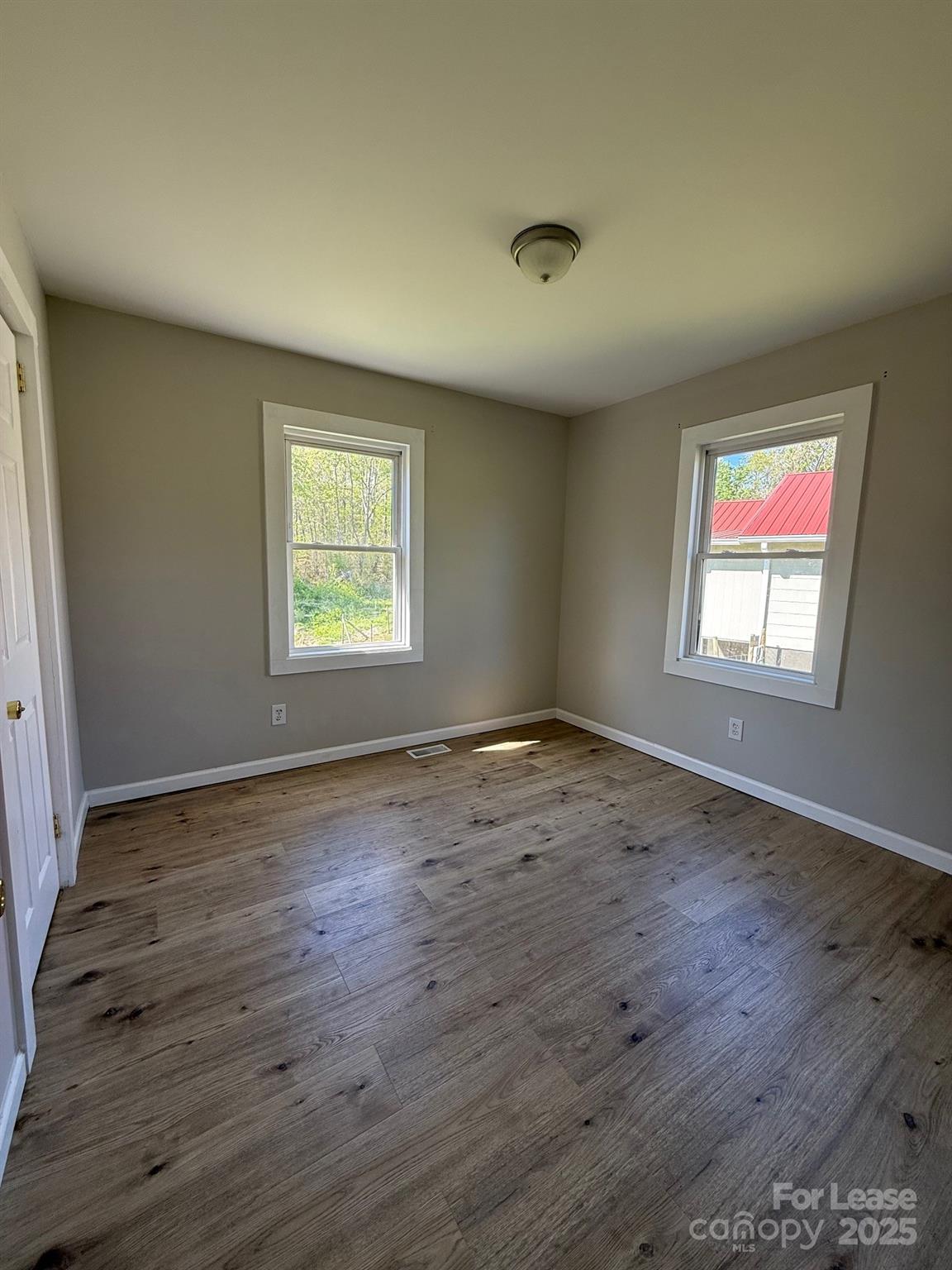 2140 Enon Road Morganton, NC 28655 - Photo 3 of 13 an empty room with wooden floor and windows