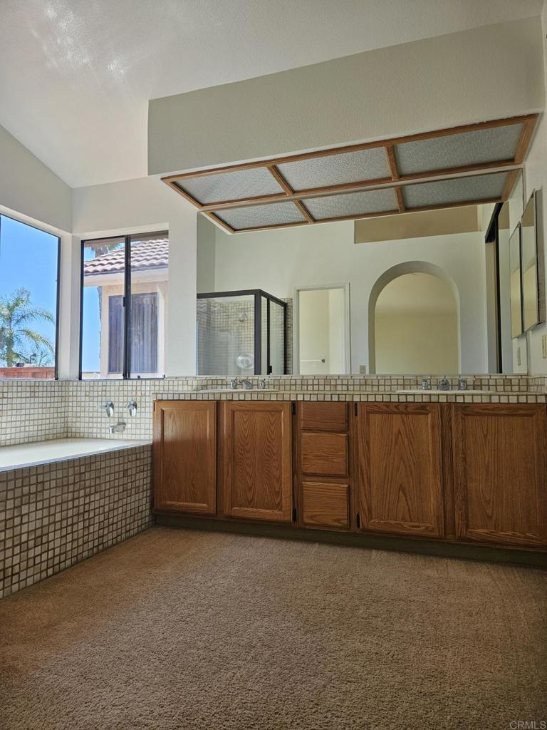 9329 Parus Point San Diego, CA 92129 - Photo 11 of 30 a bathroom with a sink a mirror and a bathtub