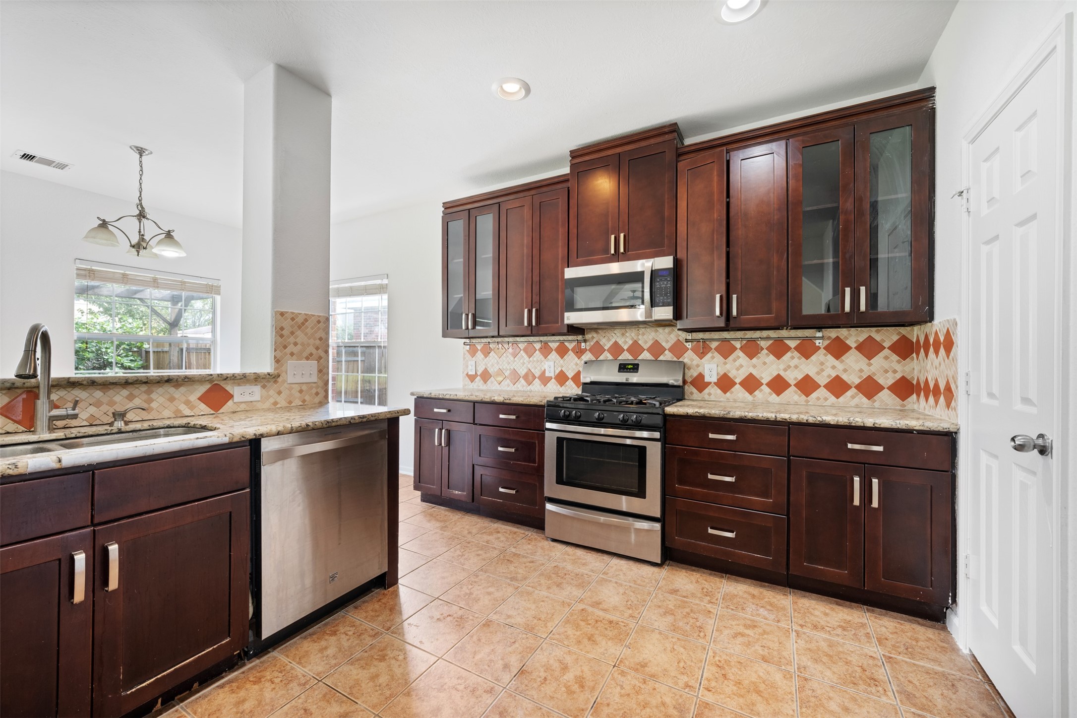 6806 Stableton Lane Houston, TX 77049 - Photo 19 of 50 a kitchen with stainless steel appliances granite countertop wooden cabinets and a stove top oven