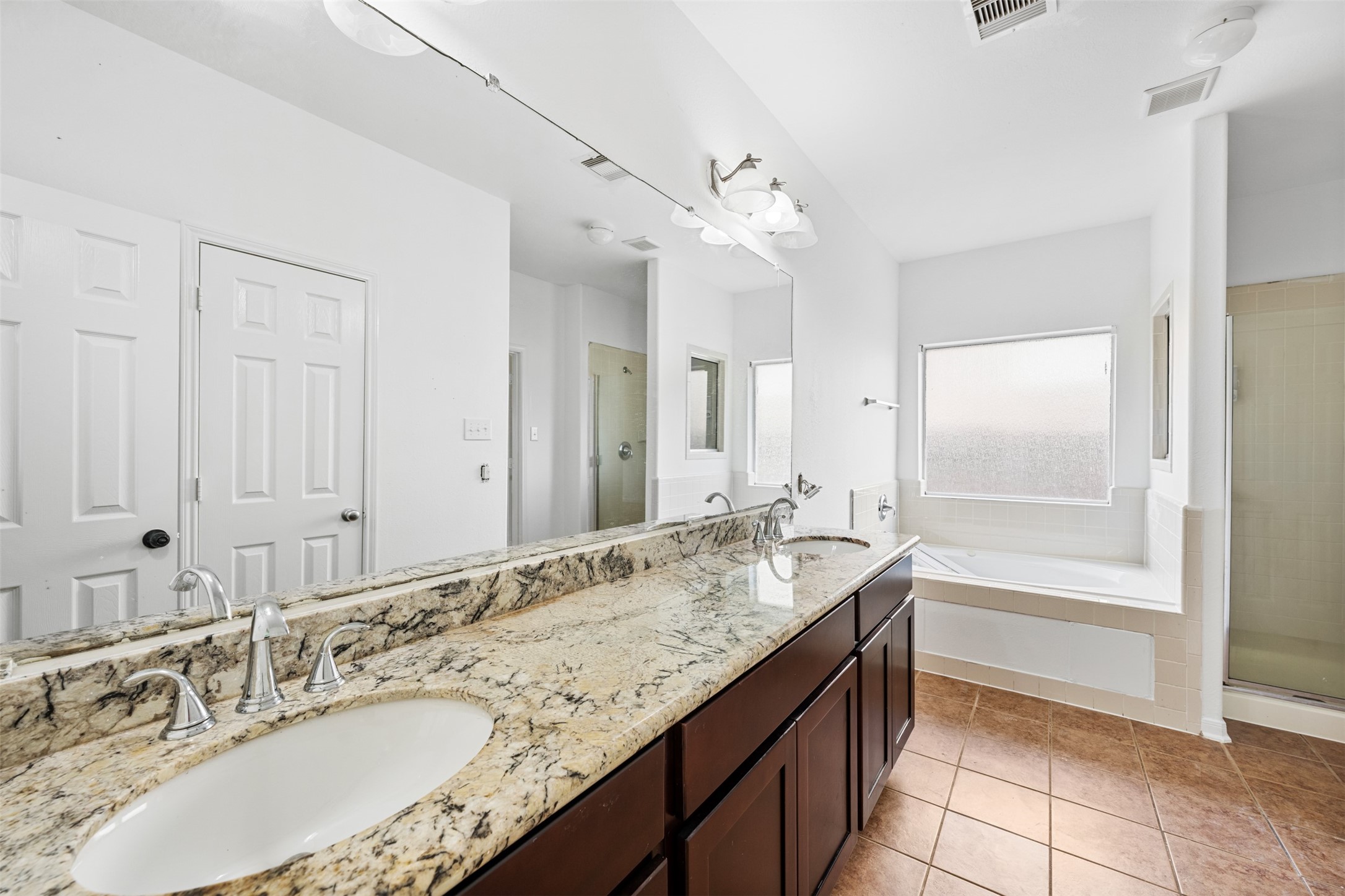 6806 Stableton Lane Houston, TX 77049 - Photo 23 of 50 a bathroom with a granite countertop double vanity sink a mirror and a bathtub