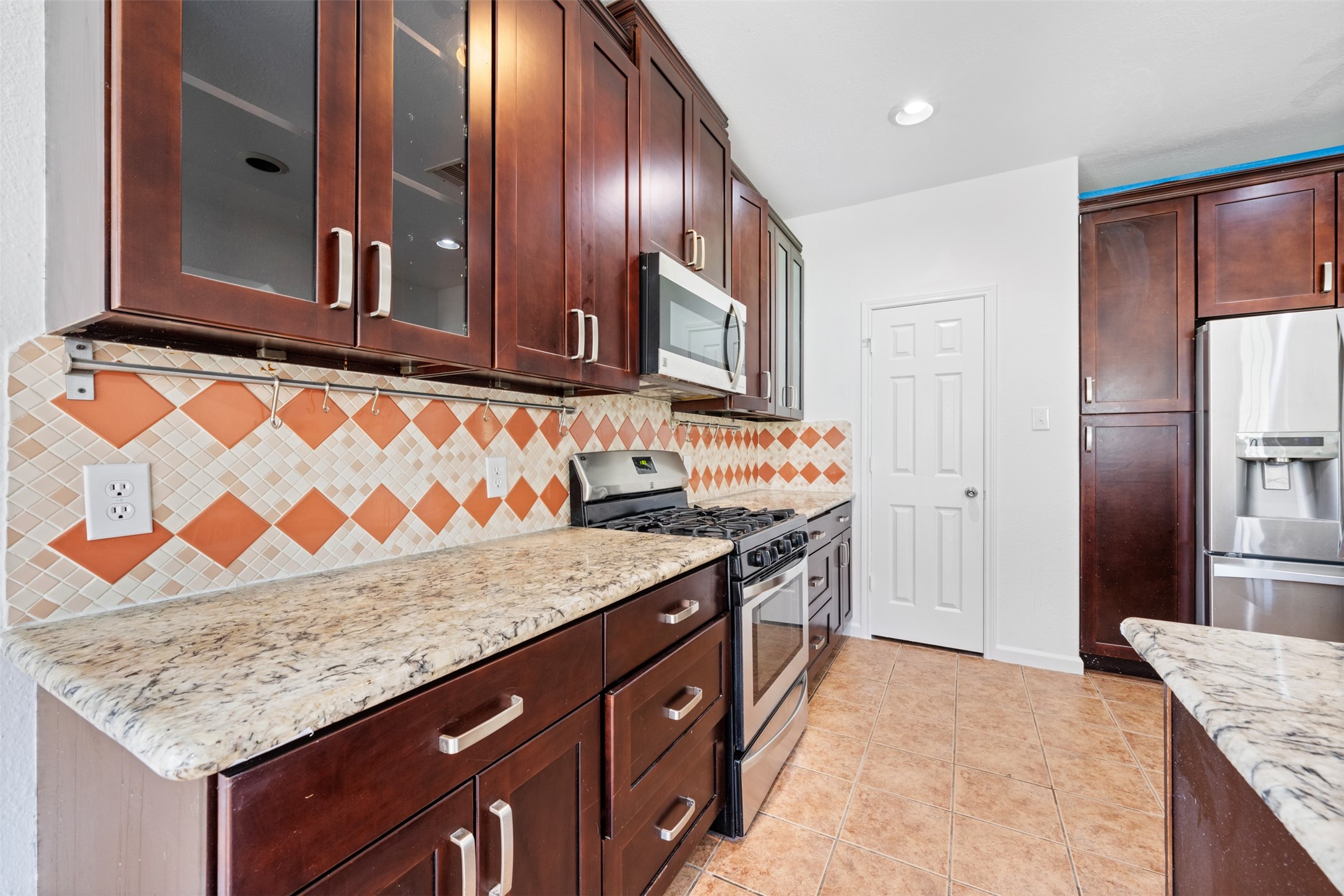 6806 Stableton Lane Houston, TX 77049 - Photo 47 of 50 a kitchen with granite countertop wooden cabinets and stainless steel appliances