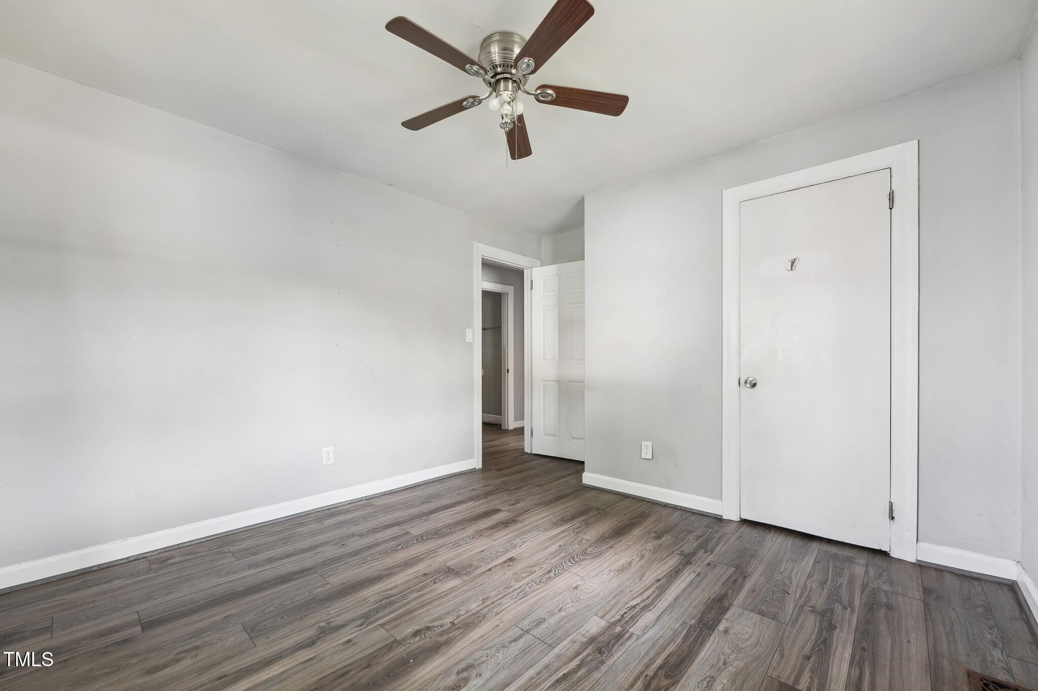 6316 Ward Boulevard Wilson, NC 27893 - Photo 10 of 36 an empty room with wooden floor and a ceiling fan