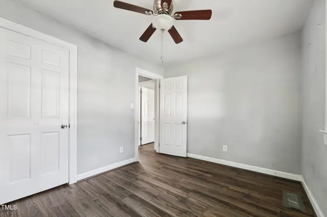 a view of a big room with wooden floor and windows