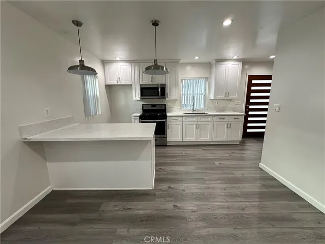 a large white kitchen with a stove a sink and dishwasher