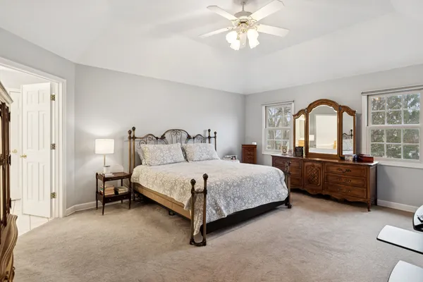 a bedroom with a large bed and a chandelier