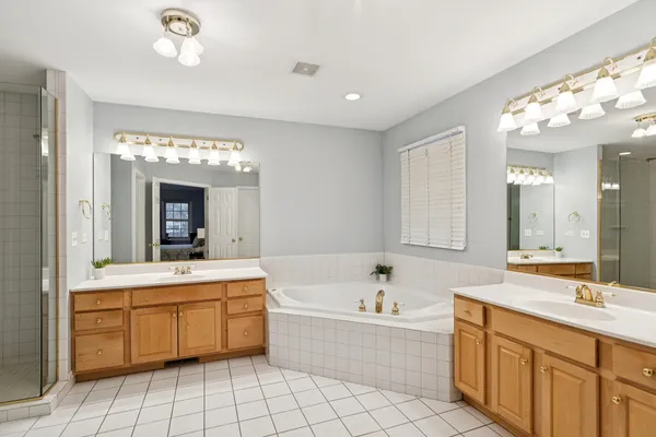 a bathroom with a tub sink and mirror