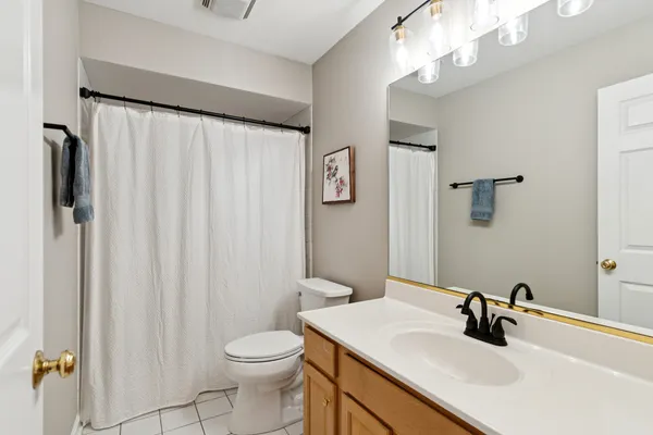 a bathroom with a sink a toilet and shower curtain