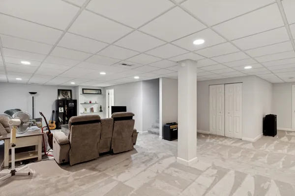 a living room with furniture and a refrigerator