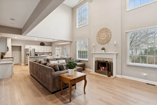a living room with furniture a fireplace and a large window