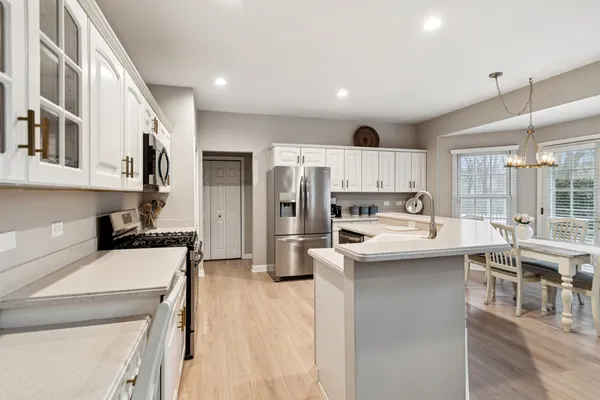 a kitchen with stainless steel appliances kitchen island granite countertop a refrigerator and a stove top oven