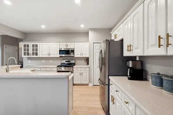 a kitchen with stainless steel appliances granite countertop a refrigerator stove top oven and sink