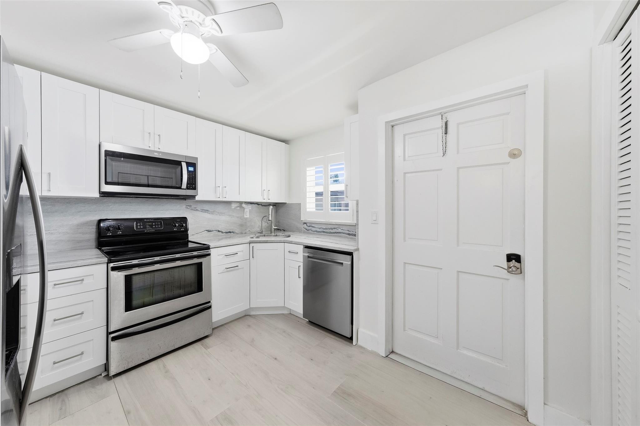 1450 North Riverside Drive, Unit 201 Pompano Beach, FL 33062 - Photo 17 of 30 a kitchen with cabinets stainless steel appliances and a counter space