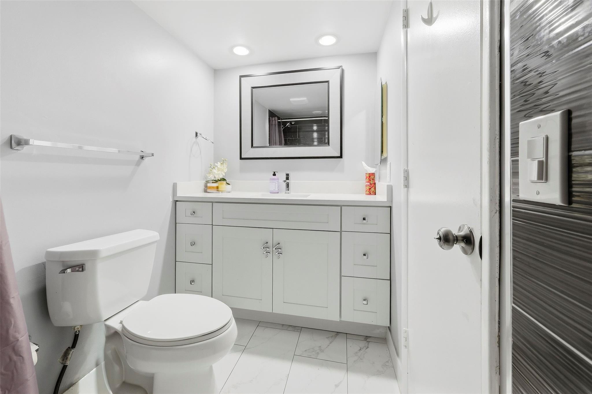 1450 North Riverside Drive, Unit 201 Pompano Beach, FL 33062 - Photo 10 of 30 a bathroom with a toilet sink and mirror