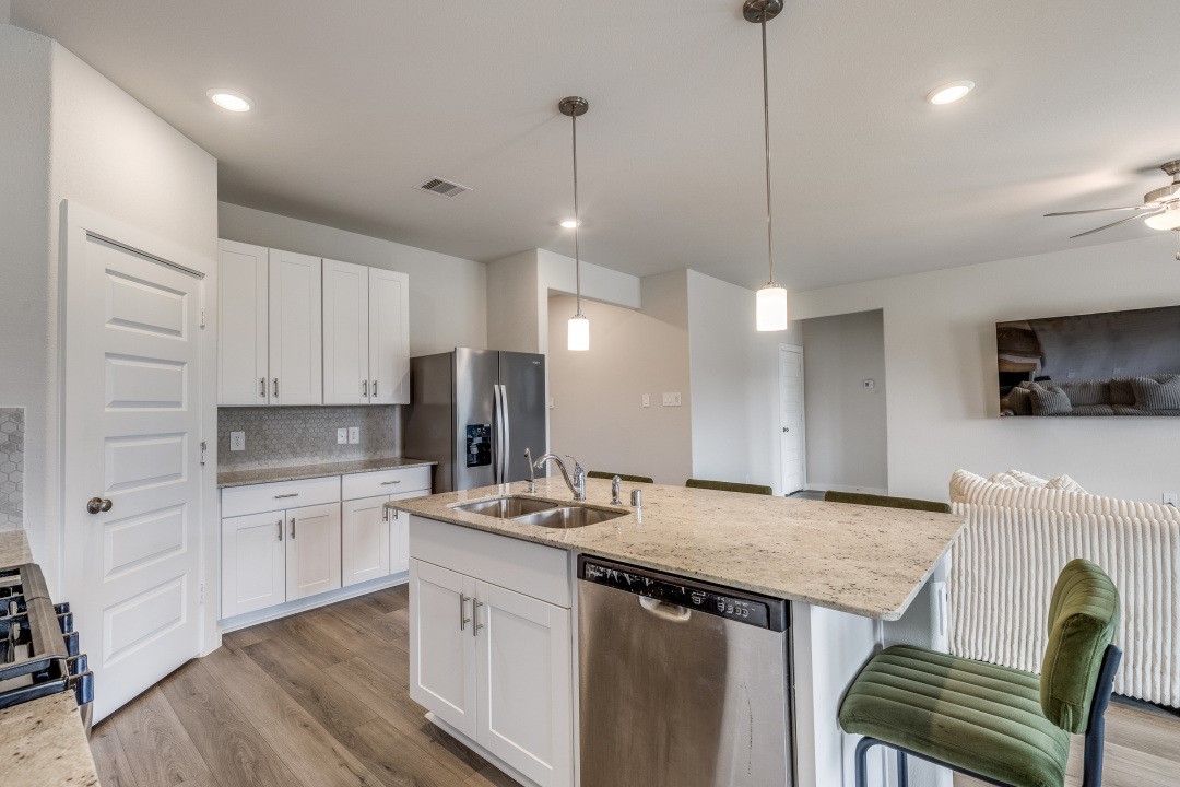 1318 Cascade Hls Drive Rosharon, TX 77583 - Photo 11 of 25 a kitchen with kitchen island a stove a sink and a refrigerator