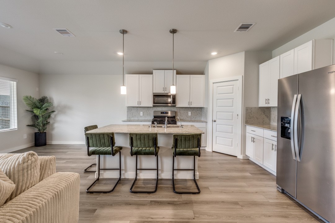 1318 Cascade Hls Drive Rosharon, TX 77583 - Photo 10 of 25 a kitchen with stainless steel appliances granite countertop a refrigerator a sink a stove a dining table and chairs