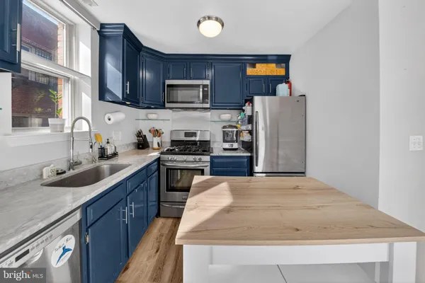 a kitchen with stainless steel appliances granite countertop a sink stove microwave and refrigerator