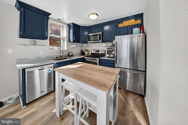 a kitchen with a refrigerator a microwave a sink and cabinets