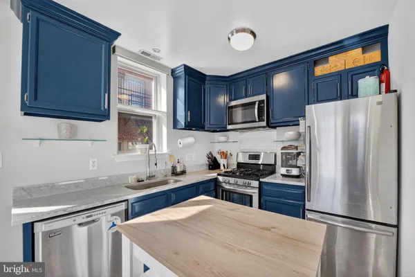 a kitchen with granite countertop a refrigerator stove top oven and sink