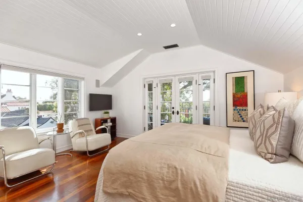a spacious bedroom with a bed and glass windows