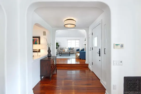 a view of a living room with kitchen island wooden floor and window