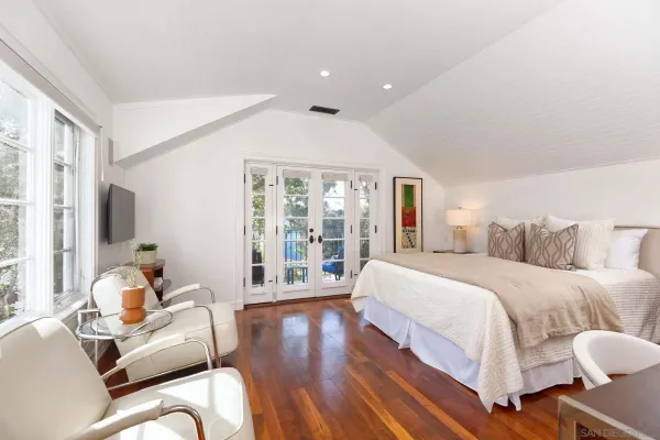 a spacious bedroom with a bed and glass window