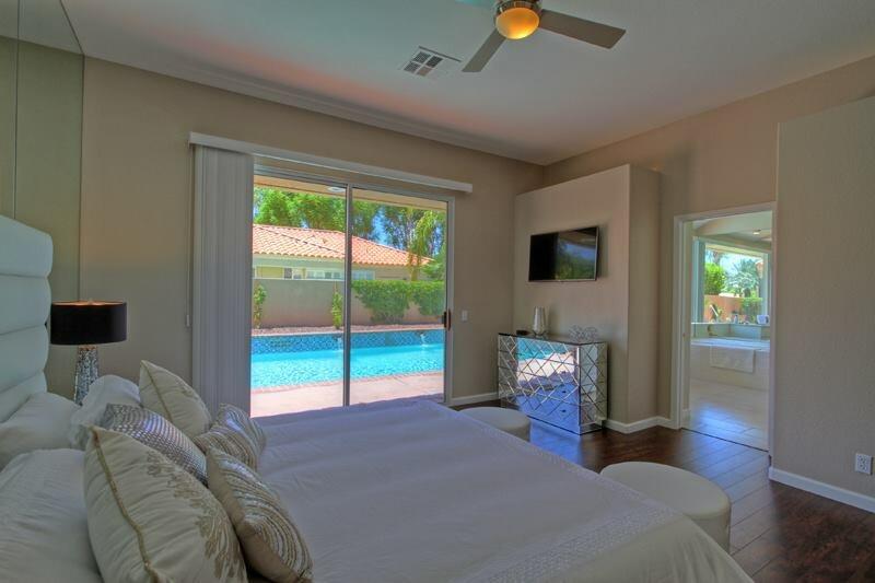 65 La Costa Drive Rancho Mirage, CA 92270 - Photo 16 of 22 a bedroom with a bed and a chandelier