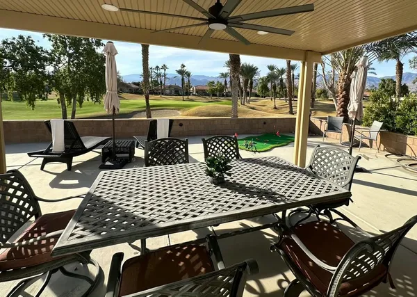 a view of a patio with a table chairs and a backyard