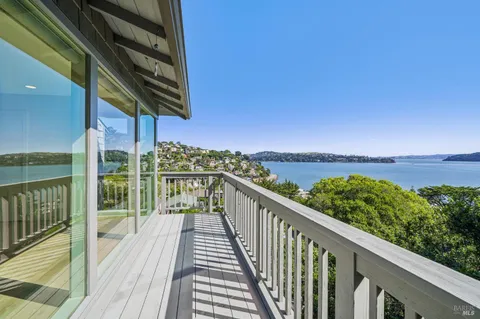 a view of a balcony with wooden floor & fence