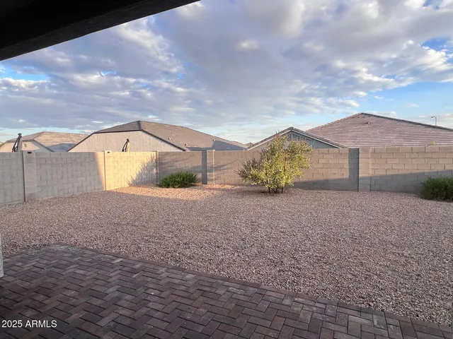 a view of a house with a yard and a large tree