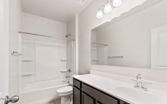 a bathroom with a sink a toilet a mirror and shower