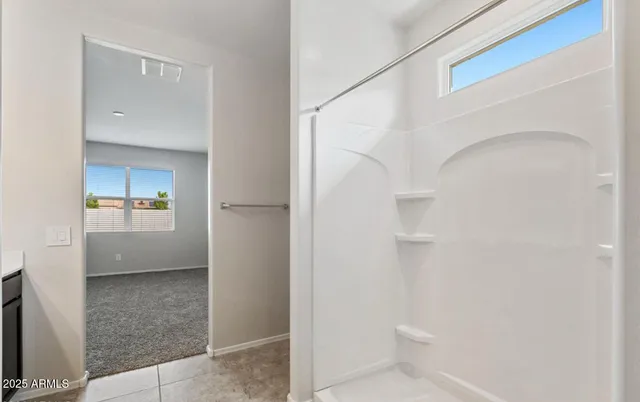 a view of a walk in closet and a bathroom