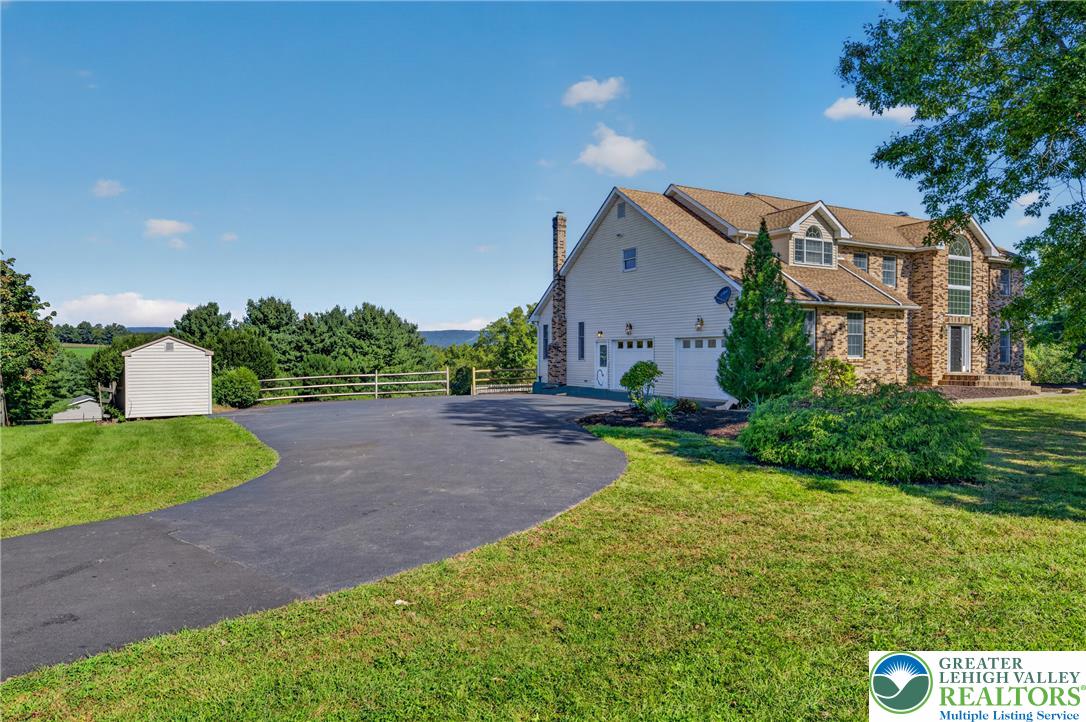 630 Clearfield Road Nazareth, PA 18064 - Photo 5 of 100 An expansive asphalt driveway leads past a detached storage shed to the attached garage.