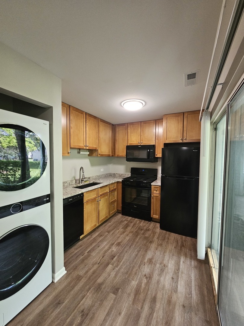 56 North Victoria Lane, Unit C Streamwood, IL 60107 - Photo 11 of 11 a kitchen with granite countertop a refrigerator stove and sink