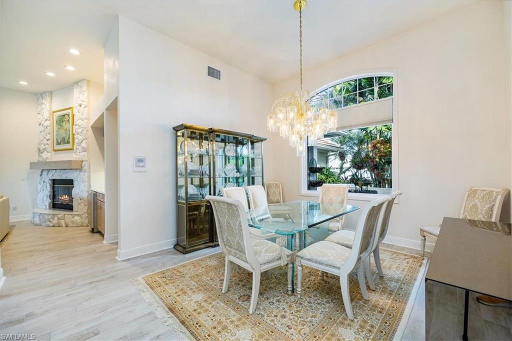 559 Eagle Creek Drive Naples, FL 34113 - Photo 7 of 26 a view of a dining room with furniture wooden floor and chandelier
