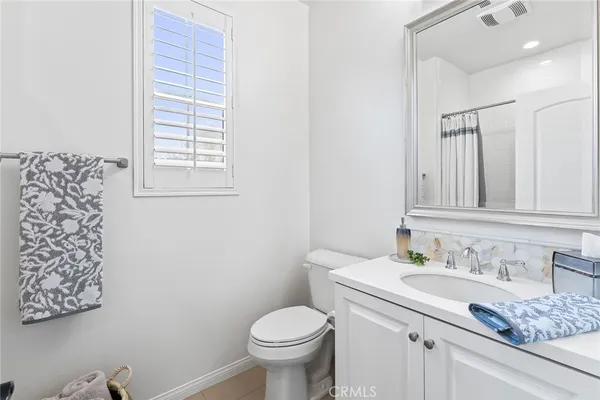 a bathroom with a granite countertop sink and a toilet
