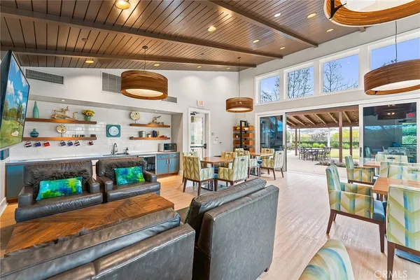 a view of a chairs and tables in the patio with a small yard