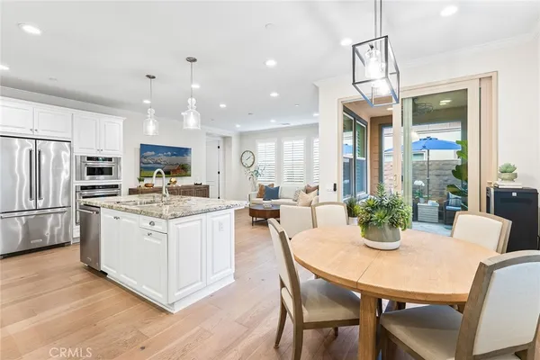 a kitchen with a dining table chairs stainless steel appliances and cabinets