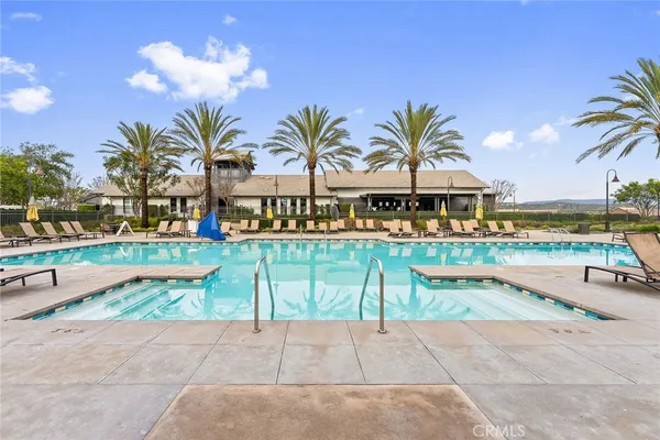 a view of a swimming pool with lounge chairs on the terrace