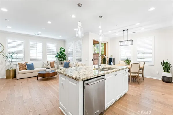 a living room with furniture kitchen view and large windows