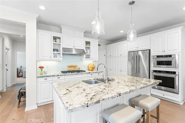 a kitchen with stainless steel appliances granite countertop a sink refrigerator and cabinets