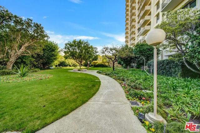 a view of a tennis ground with large trees