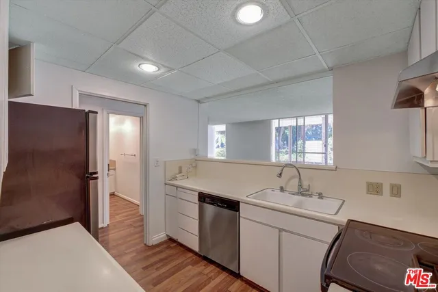 a kitchen with a refrigerator sink and cabinets