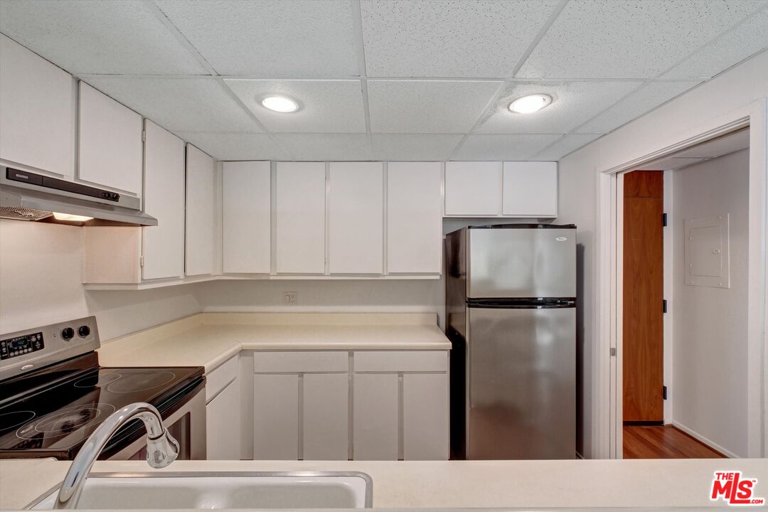2160 Century Park East, Unit 103 Los Angeles, CA 90067 - Photo 8 of 37 a kitchen with a refrigerator sink and cabinets