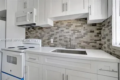 a kitchen with a stove a sink and a refrigerator