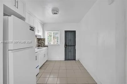a kitchen with white cabinets and white appliances