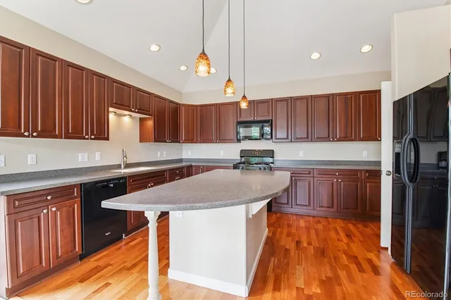 a kitchen with stainless steel appliances granite countertop a sink a stove a refrigerator and cabinets