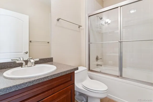 an empty room with a chandelier fan and windows