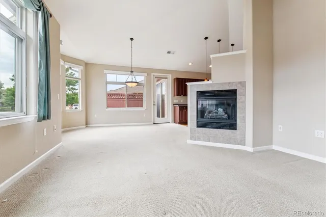 a view of an empty room with a fireplace and a window