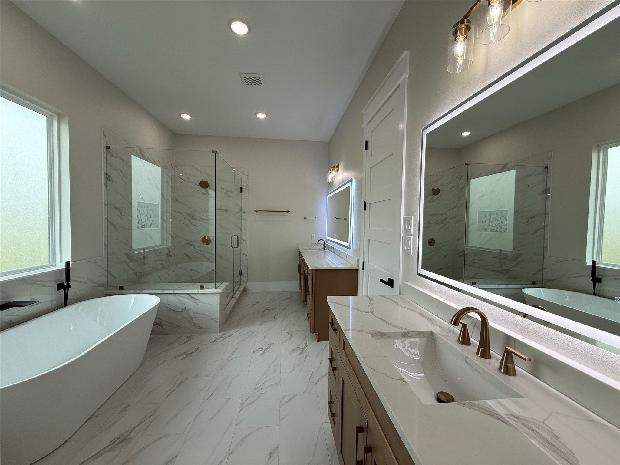 1214 Quarter Horse Trail Angleton, TX 77515 - Photo 20 of 32 a bathroom with a double vanity sink a mirror and a bathtub
