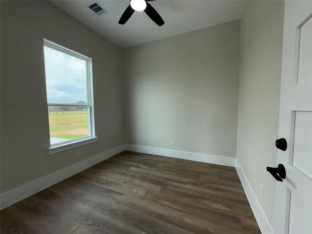 a view of a livingroom with wooden floor and a window